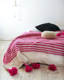 white blanket with Pink stripes and pompoms